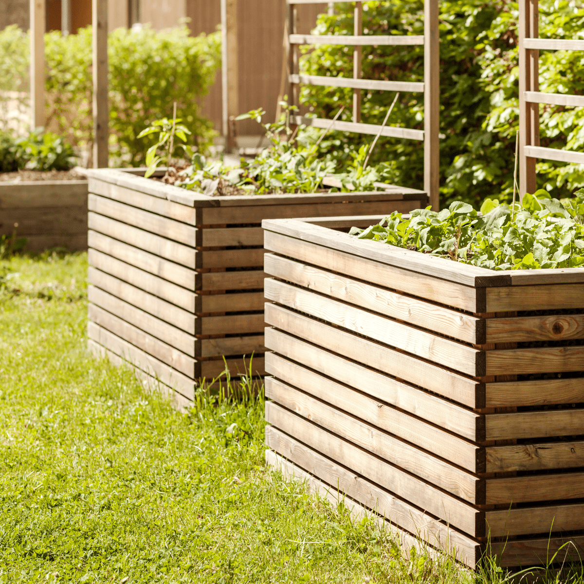 Zwei große, rechteckige Hochbeete aus horizontalen Holzlatten im Rasen.